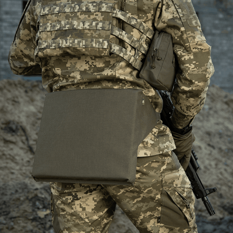 M-Tac Siddeunderlag med bælte på en kamuflage uniform, velegnet til udendørs brug og militært udstyr.