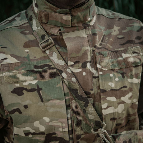 Kamufleret uniform med strop i skovmønster for en taktisk opgave i naturindstillinger.