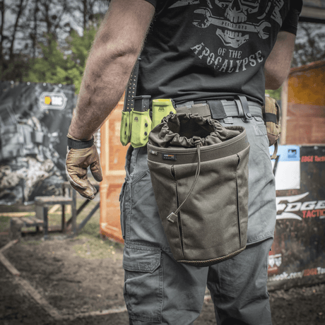 Henkilö kantaa M-Tac Mag Drop Pouch Elite -taskua kiinnitettynä varusteisiin MOLLE-kiinnikkeillä nopeaa pääsyä varten.