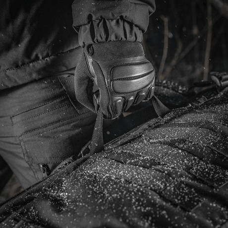 Nærbillede af M-Tac Rygsæk Gen.II Elite Large i Cordura materiale, holdt af handske i snevejr
