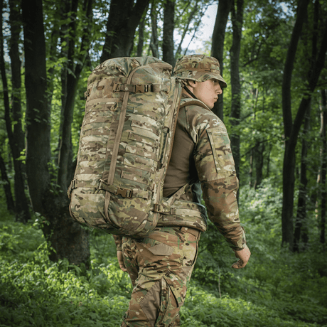 Person med M-Tac Rygsæk Gen.II Elite Large i camouflage i skovmiljø