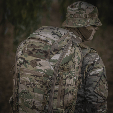 M-Tac Large Gen.IV Elite maastokuvioitu reppu ulkoilmassa, valmistettu kulumiskestävästä Cordura-materiaalista.