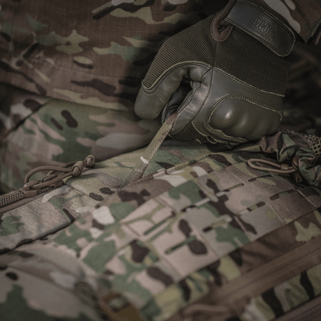 Yksityiskohtainen kuva M-Tac Large Gen.IV Elite -repusta käytössä, näyttää kestävän Cordura-materiaalin maastokuvioinnilla.