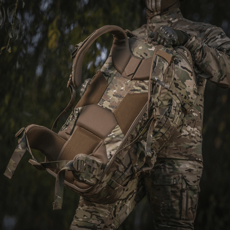 M-Tac Large Gen.IV Elite maastokuvio, ergonominen muotoilu, pidetään sotilaspukuisen henkilön toimesta luonnossa.