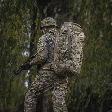 Sotilas metsäympäristössä kantaa maastokuvioitua M-Tac Large Gen.IV Elite -reppua.