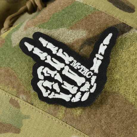 M-Tac Bat Wing Bag Elite luurankokuvioinnilla, valmistettu kestävästä Cordura-materiaalista, YKK-vetoketjut ja Woojin-soljet.