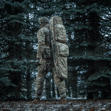 Henkilö metsässä M-Tac Gun Backpack Case 125 cm Gen.II Elite mukana, camo