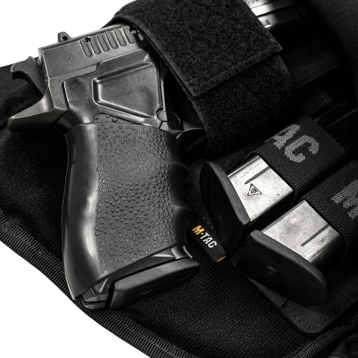 M-Tac Double Mag Pouch Hook Backed Magazine med en pistol og magasiner i et velcrofastgjort etui.