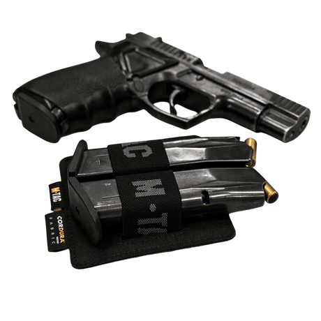 M-Tac Double Mag Pouch Hook Backed Magazine kahdella lippaalla pistoolin vieressä mustalla taustalla