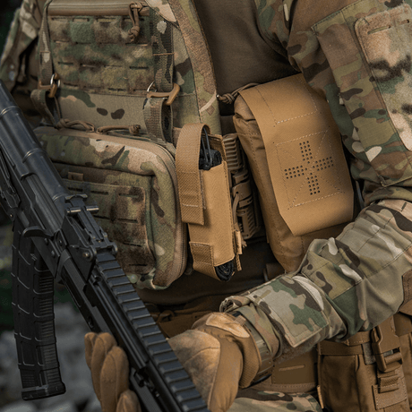 M-Tac Tourniquet Pouch Elastisk VELCRO Gen.II sotilaalla taktisen varustuksen ja maastokuosion kanssa