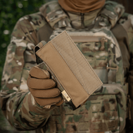 M-Tac Tourniquet Pouch Elastisk VELCRO Gen.II maastoympäristössä, pidetty taktisen varustuksen kantajan toimesta