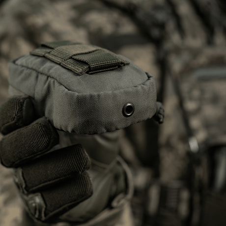 M-Tac PC Utility Pouch Elite taktisia varusteita käyttävän henkilön kädessä, sopii pienten tavaroiden säilytykseen