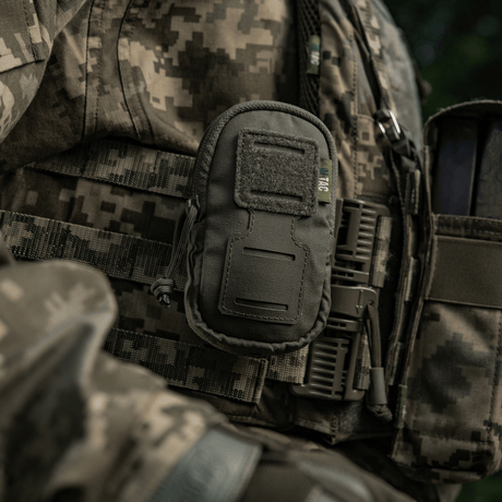 Sotilas, jolla M-Tac PC Utility Pouch Elite kiinnitetty MOLLE-järjestelmään, monikäyttöinen Cordura-laukku pikkutavaroille taktisissa oloissa.