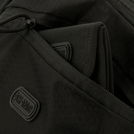 Lähikuva M-Tac Sphaera Hex Hardsling Bag vetoketjukompartmenteilla ja M-Tac-merkinnällä, valmistettu kestävästä Cordura/Hex-polyesteristä.