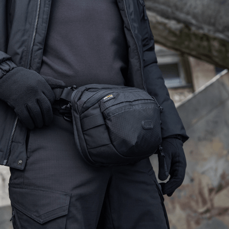 M-Tac Sphaera Hex Hardsling Bag käytössä olka- tai vyölaukkuna, kompakti muotoilu, piilotettu aseenkotelo, Cordura/Hex-polyesteristä.