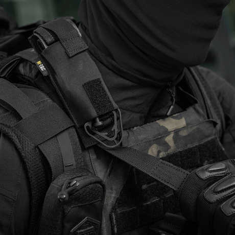 M-Tac Tourniquet Pouch Elastisk med MOLLE Gen.II kiinnitetty taktiikkaiseen liiviin, Cordura Squadron -materiaalista, varmistettu elastisella kiinnityksellä ja MOLLE-järjestelmällä.