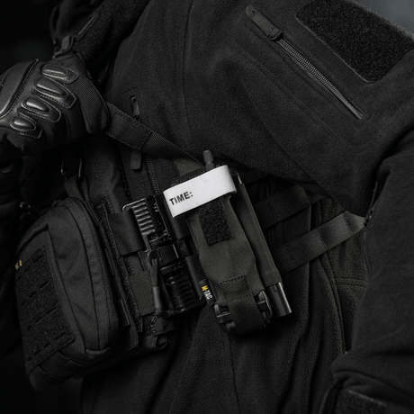 M-Tac Elastisk Tourniquet Pouch Molle Gen.III kannettuna taktisen varusteen osana, Cordura-materiaalia, suunniteltu nopeaan tourniquetin käsittelyyn.
