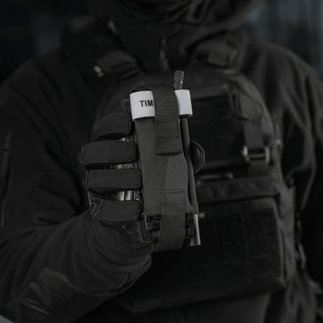 Taktinen käyttäjä pitää M-Tac Elastisk Tourniquet Pouch Molle Gen.III Cordura Squadronista leveällä kuminauhalla ja nopealla pääsyllä.