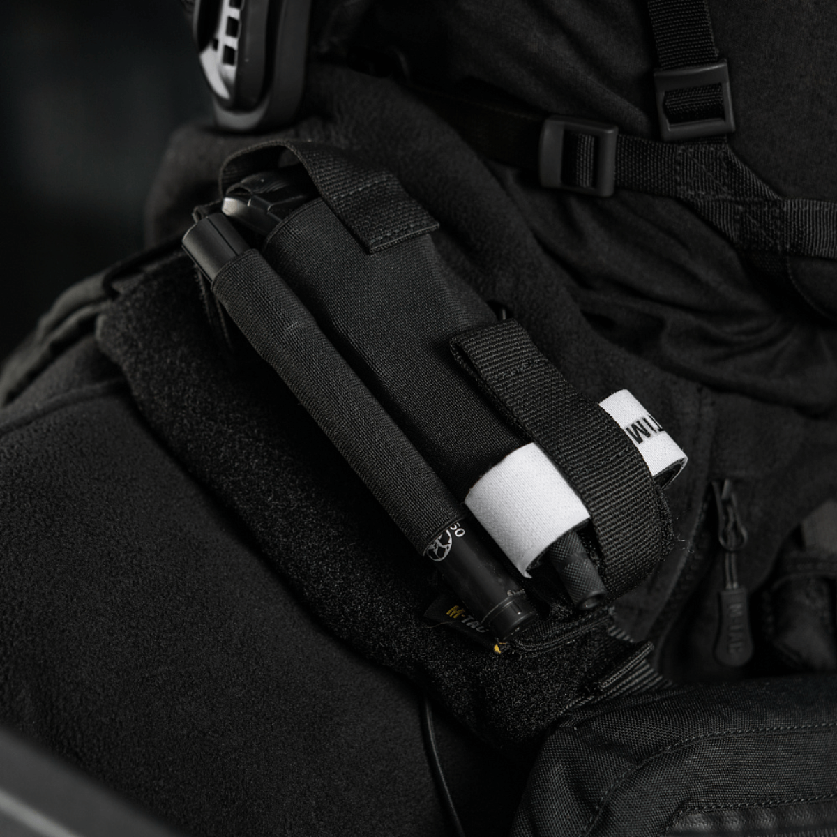 M-Tac Elastisk Tourniquet Pouch Molle Gen.III monteret på uniform, viser elastisk holder og hurtig adgangssystem.