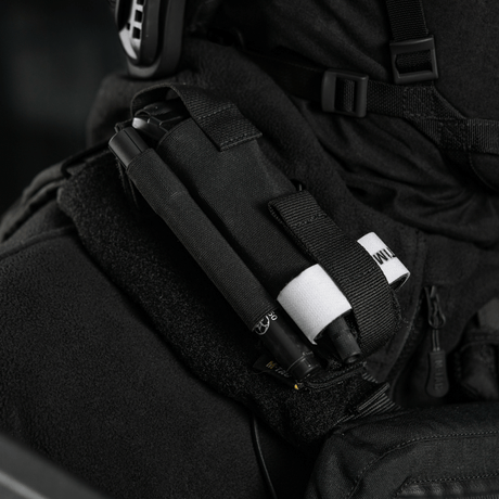 M-Tac Elastisk Tourniquet Pouch Molle Gen.III kiinnitettynä univormuun, näyttää joustavan pidikkeen ja nopean pääsyjärjestelmän.