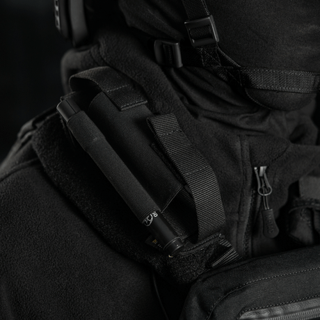 M-Tac Elastisk Tourniquet Pouch Molle Gen.III nopeaa pääsyä ja turvallista tourniquetin säilytystä varten, kiinnitettynä taktiseen varusteeseen.