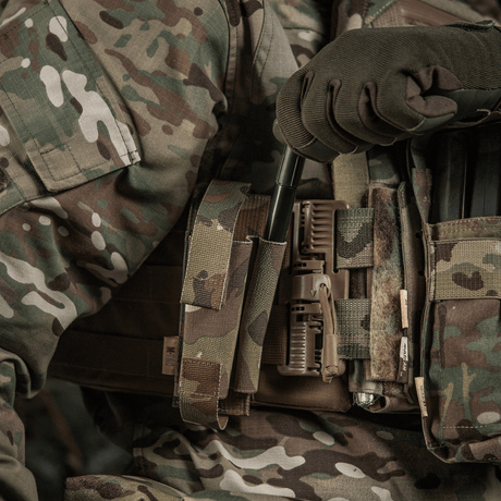 M-Tac Elastinen turnikekotelo Molle Gen.III käytössä, kiinnitetty maastokuvioiseen sotilasliiviin leveällä elastilla kiinnitystä varten.