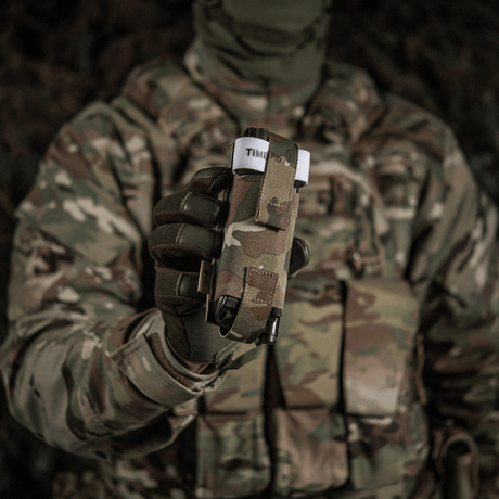 Sotilas maastopuvussa pitää M-Tac Elastinen turnikekotelo Molle Gen.III edessään, valmiina nopeaan käyttöön.