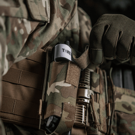 M-Tac Elastinen turnikekotelo Molle Gen.III maastokuviossa, kiinnitetty taktiseen liiviin tourniquet näkyvissä.