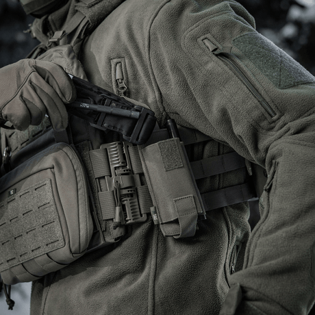 M-Tac Elastinen turnikekotelo Molle Gen.III kiinnitetty taktiseen liiviin, osoittaa nopeaa käyttöä ja turvallista säilytystä tourniquetille.