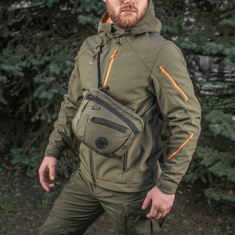 M-Tac Sphaera Hex Hardsling Gen.II Elite miehellä sotilasvihreissä vaatteissa luonnossa.