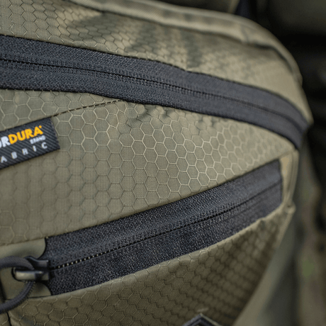 M-Tac Sphaera Hex Hardsling Gen.II Elite Cordura-materiaalilla, hex-kuvio ja vetoketjun yksityiskohta; korostaa toiminnallista laukunsuunnittelua.