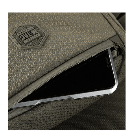 Yksityiskohta M-Tac Magnet XL Taske Elite Hexistä FidLock-lukitusjärjestelmällä ja Velcro-paneelilla, esillä älypuhelimen säilytys.