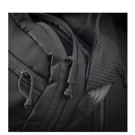Yksityiskohta M-Tac Magnet XL Taske Elite Hexistä, FidLock-lukitusjärjestelmä ja olkahihna; näyttää vahvan kankaan ja vetoketjusuunnittelun.