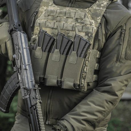 Henkilö pukeutuneena taktiseen liiviin, jossa M‑Tac Elastinen Triple Magazine Pouch Elite ja AK-lipat