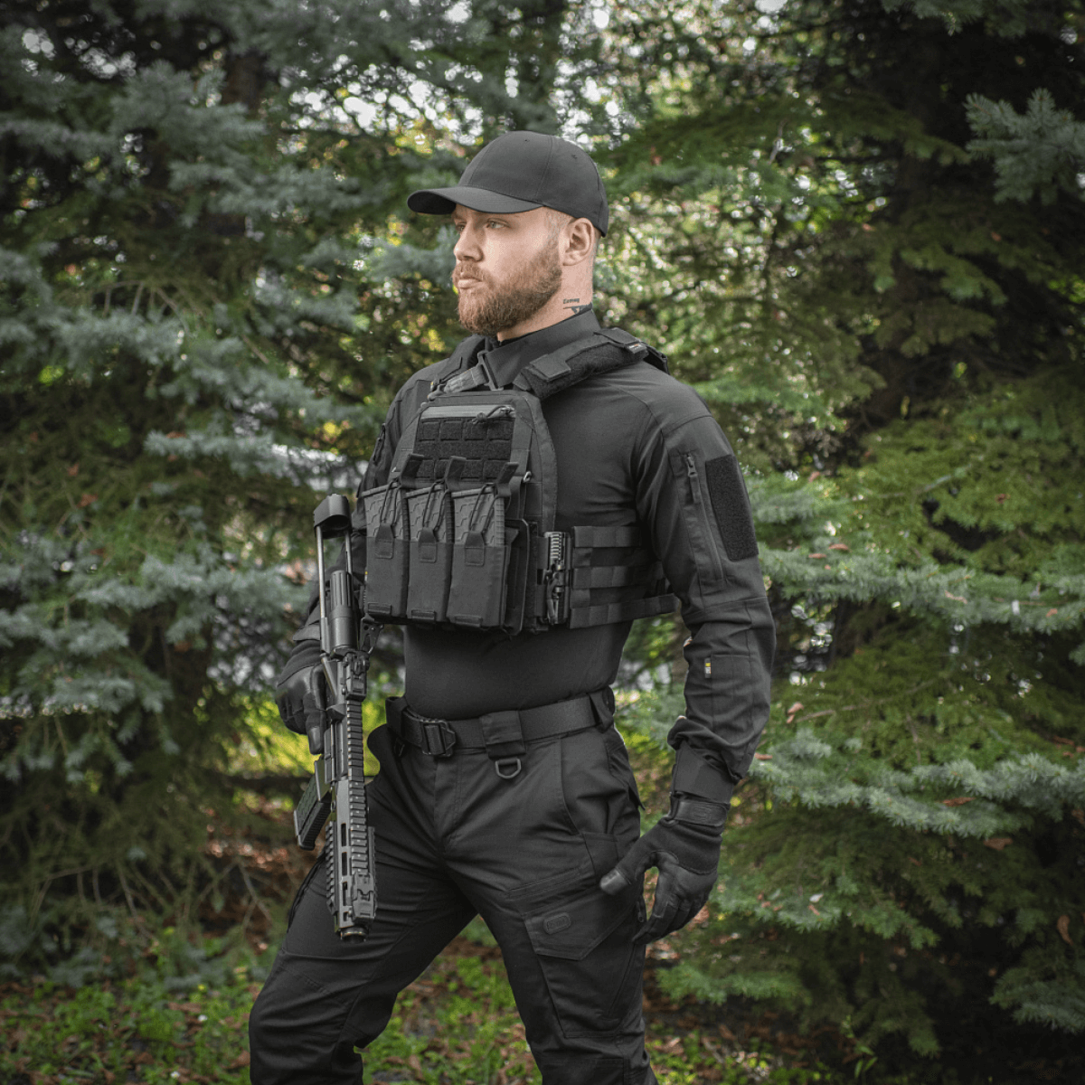 Taktisk operatør iført M‑Tac Plate Carrier Cuirass QRS Gen.II med quick-release system og ergonomisk design i skovmiljø.