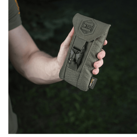 M-Tac Smartphone Lomme Elite Large Hex kädessä, valmistettu kestävästä CORDURA HEX -materiaalista WJ-magneettisoljella, musta muotoilu.