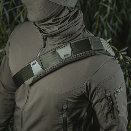 M‑Tac olkahihnan pehmike 50 mm Elite kiinnitettynä olkapäälle, 3D-mesh mukavuuteen ja Cordura kestävyyteen, käytössä taktisen takin kanssa.