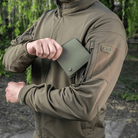 M-Tac Slim Elite Gen. II vihreänä polymeerikomposiitista pidetään takin käyttäjän toimesta, näyttää kompaktin muodon ja kulutuskestävyyden.
