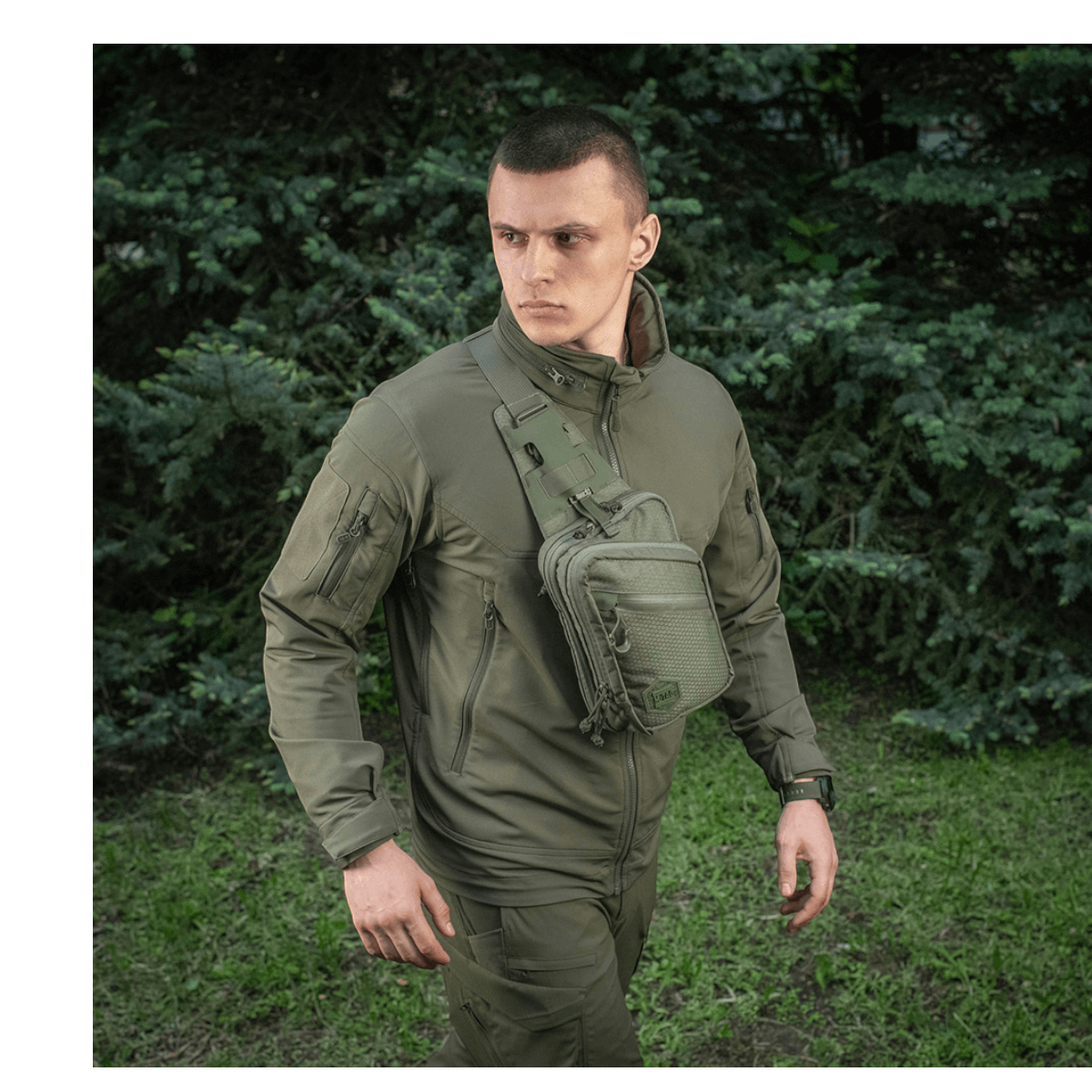 M-Tac Sling Pistoltaske Elite Hex båret af en person i udendørs omgivelser, viser taskens design og alsidighed.