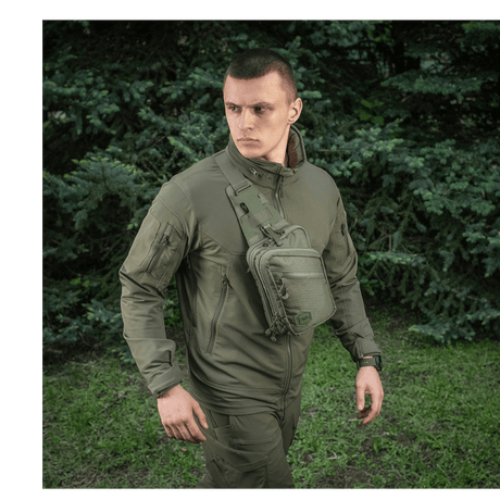 M-Tac Sling Pistoltaske Elite Hex henkilön kantamana ulkoilmassa, näyttää laukun muotoilun ja monipuolisuuden.