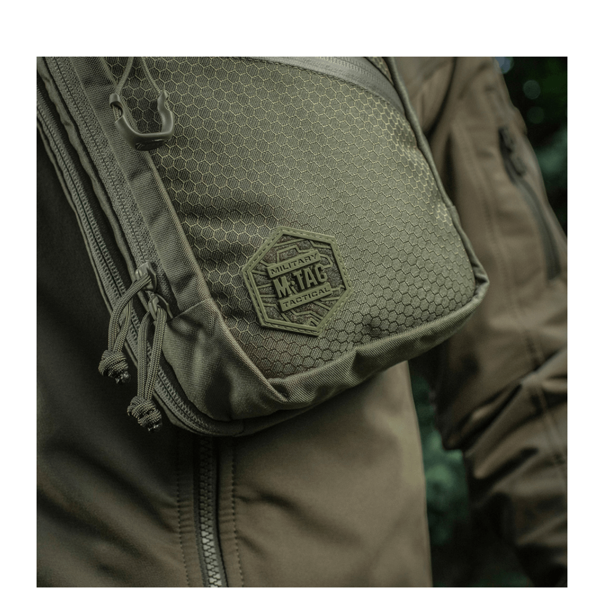 M-Tac Sling Pistoltaske Elite Hex på en person iført jakke, fremstillet i slidstærkt Cordura 1000D materiale med justerbar rem.