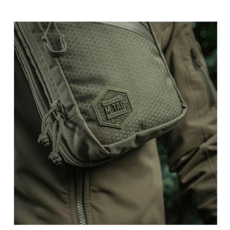 M-Tac Sling Pistoltaske Elite Hex henkilöllä takki yllä, valmistettu Cordura 1000D -materiaalista, säädettävä hihna.