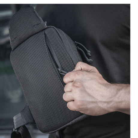 M-Tac Sling Pistoltaske Elite Hex käytössä säädettävällä olkahihnalla ja tilavilla osastoilla, valmistettu Cordura-materiaalista.