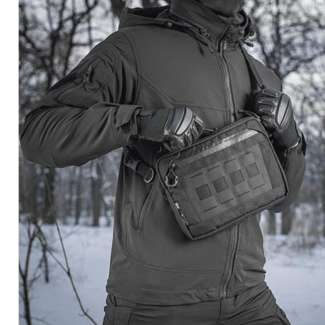 Henkilö, jolla on M-Tac Admin-laukku Elite, talvisessa metsässä