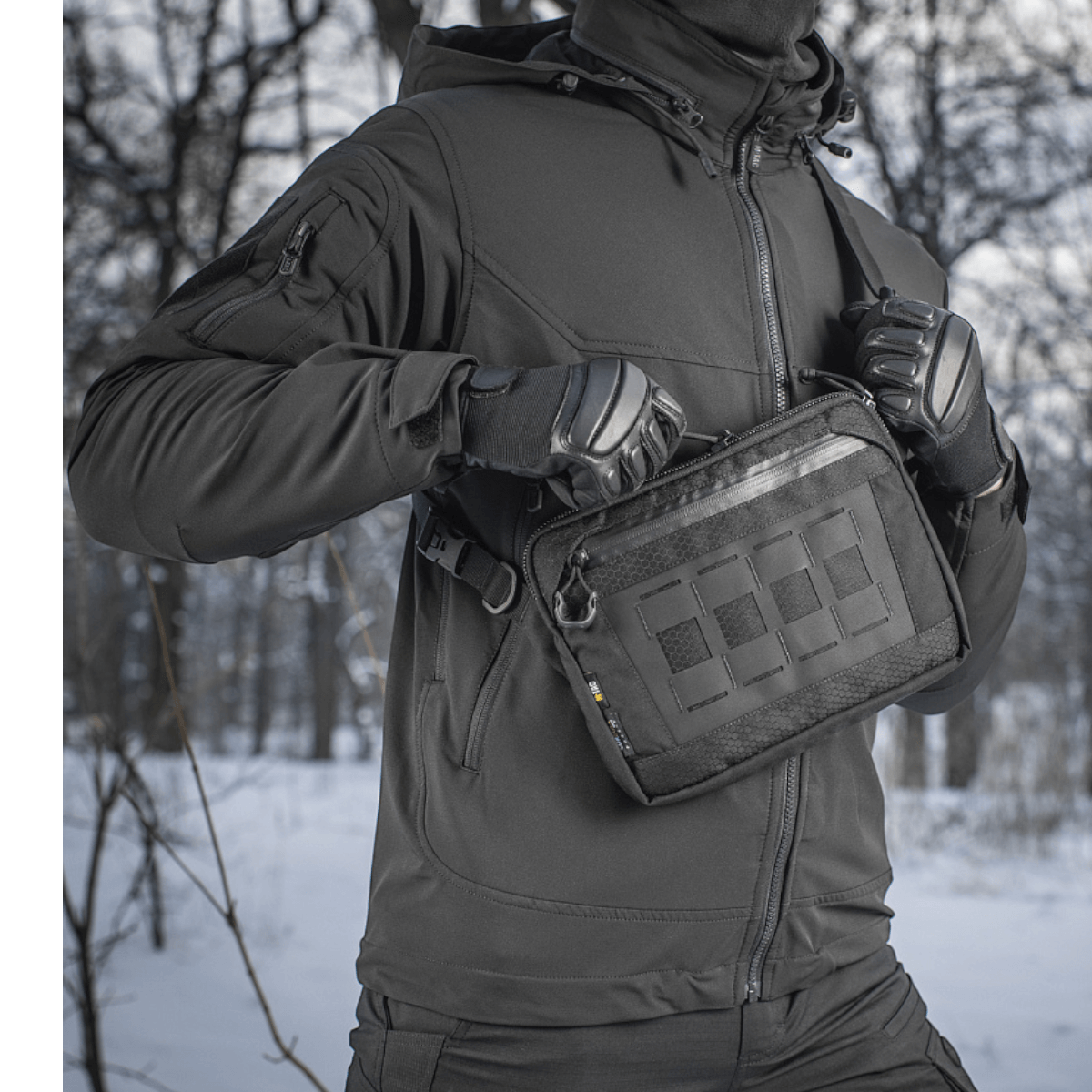 Person med M-Tac Admin Taske Elite i en vinterlig skov.