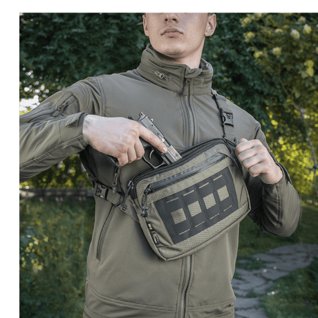 M-Tac Admin-laukku Elite käytössä henkilöllä takissa, valmiina nopeaan käyttöön, valmistettu kestävästä Cordura 500D:stä ja Cordura Hexistä