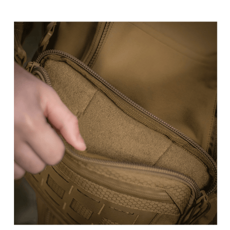 Henkilö avaa taskun M-Tac Admin-laukusta Elite, kestävä Cordura-materiaali ja YKK-vetoketjut