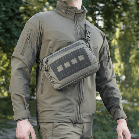 Mies kantaa M-Tac Admin-laukku Eliteä Cordura 500D:llä, säädettävä olkahihna, sopii ulkokäyttöön ja päivittäisiin aktiviteetteihin