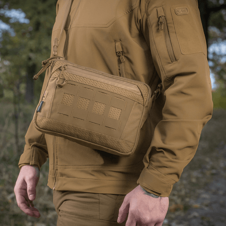 Mies kantaa M-Tac Admin-laukku Eliteä, valmistettu kestävästä Cordura 500D:stä, säädettävä olkahihna, ulkona luonnossa
