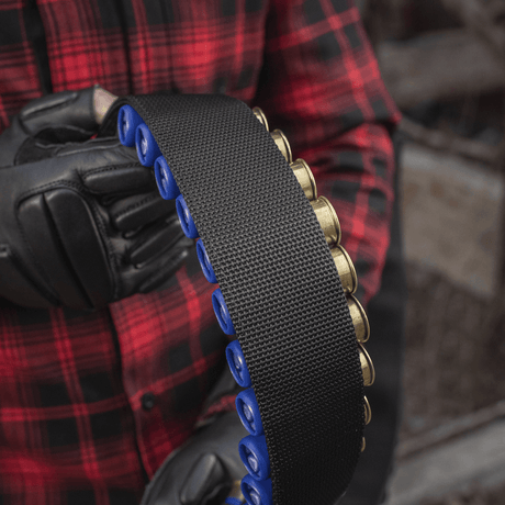 Henkilö pitelee M-Tac Bandolier Elitea, patruunavyötä jossa 55 patruunapaikkaa, sopii metsästykseen ja ampumaurheiluun.